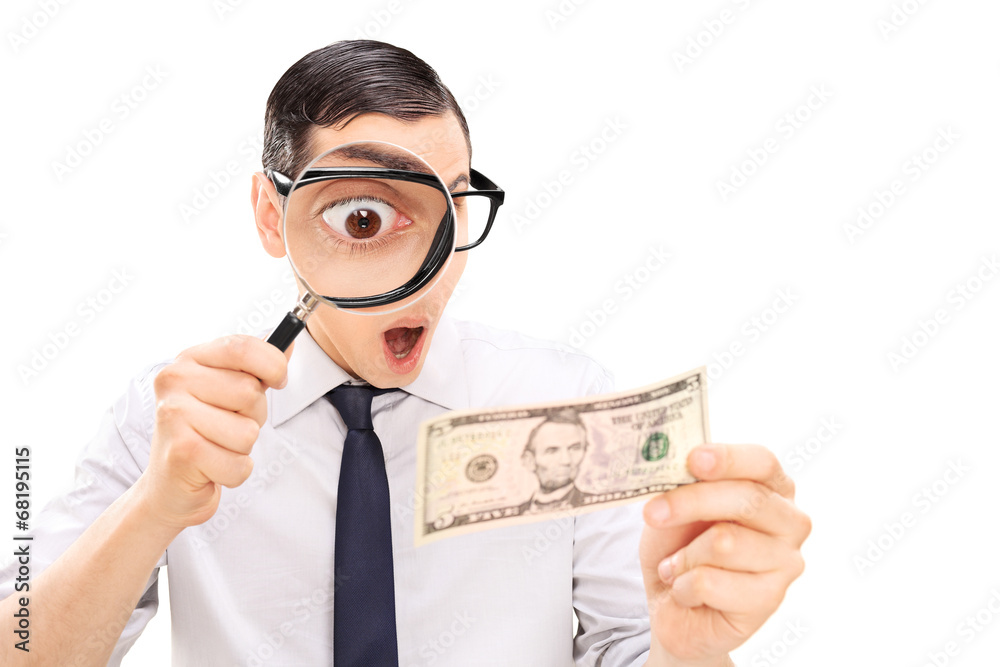 Excited man looking at dollar bill with magnifier Excited man looking at dollar bill with magnifier