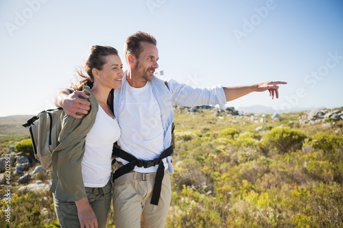 Hiking couple pointing and smiling on country terrain