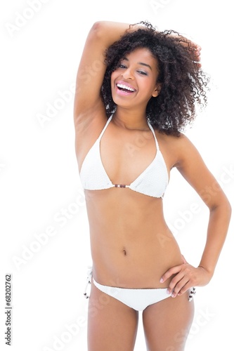 Fit girl in white bikini smiling at camera