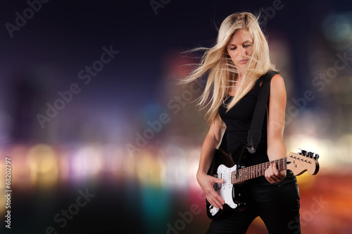 Beautiful blond girl playing on guitar