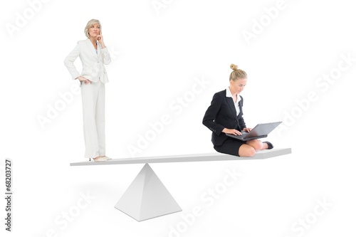 White scales measuring two businesswomen