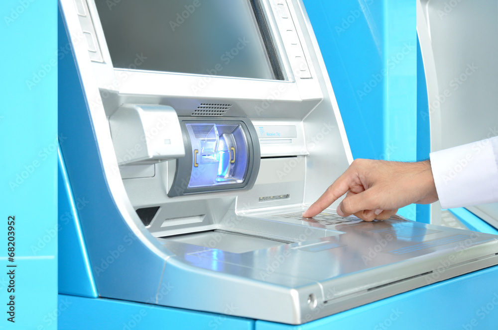 ATM (Automated Teller Machine) with hand pressing on the keypad ATM (Automated Teller Machine) with hand pressing on the keypad