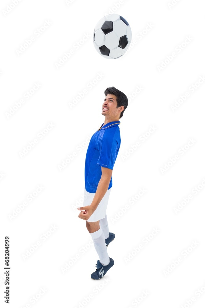 Football player in blue heading ball