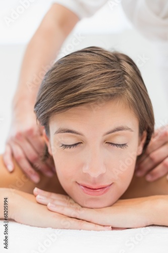 Attractive woman receiving shoulder massage at spa center