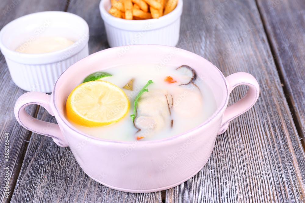 Tasty soup with oysters on wooden table Tasty soup with oysters on wooden table