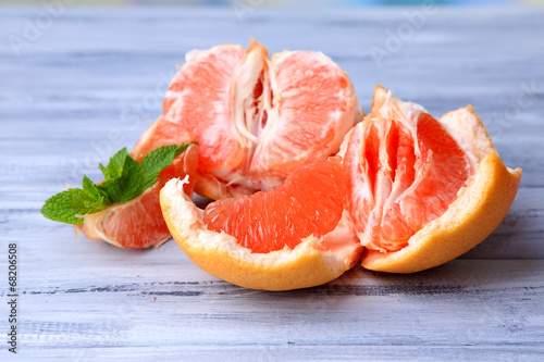 Ripe peeled grapefruits on color wooden background
