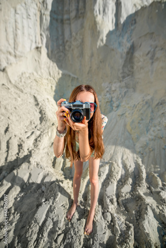 Woman traveler taking photo on the sandy background
