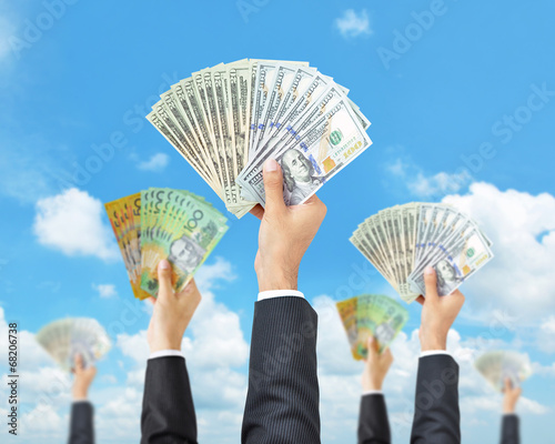 Hands holding money in multi currencies -money raising & funding