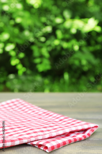 Wooden table with tablecloth, outdoors