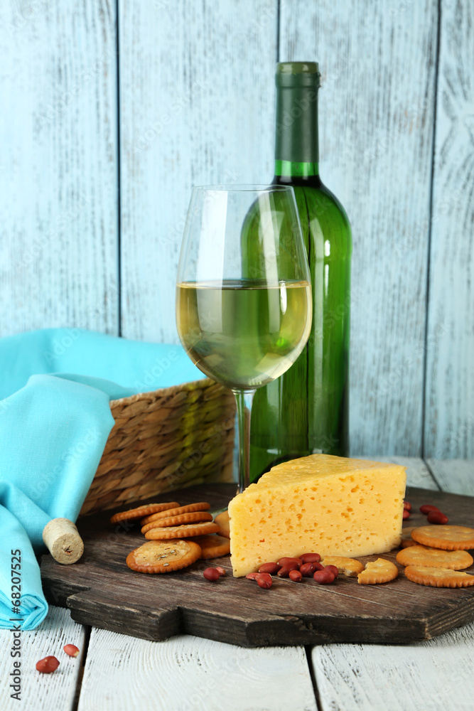 Naklejka premium Wine, cheese and crackers on wooden table close-up