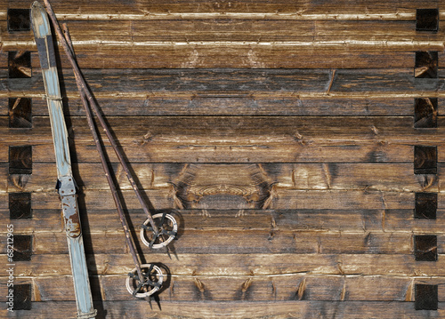 Historic blue ski with poles on wooden wall