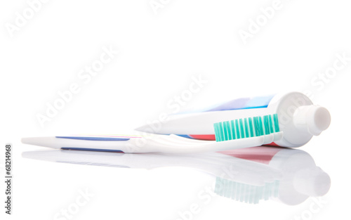Toothbrush and toothpaste over white background
