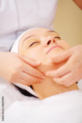 Massage of face at beauty treatment salon