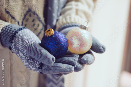 Woman wearing gloves and holding Christmas balls