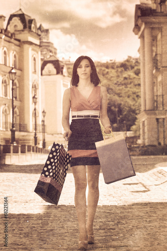 beautiful young woman holding shopping bags on a city street