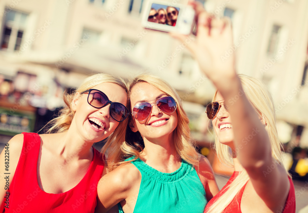 girls taking picture with camera in the city girls taking picture with camera in the city