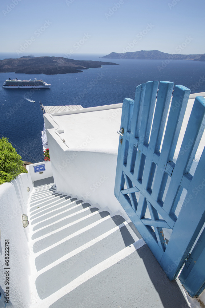 Naklejka premium drzwi i schody z morskim statkiem na Santorini
