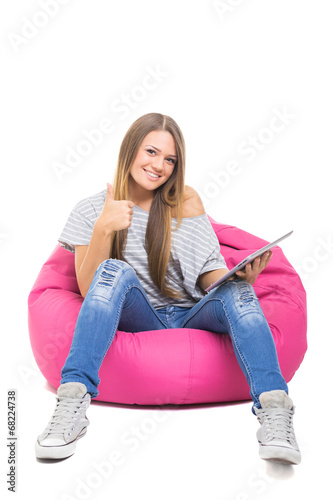 Cute teenage girl with tablet gesturing thumbs up