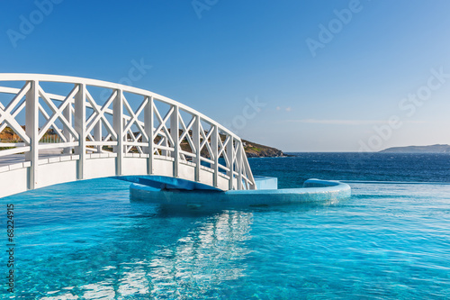 Wooden footbridge over luxury swimming pool #68224915