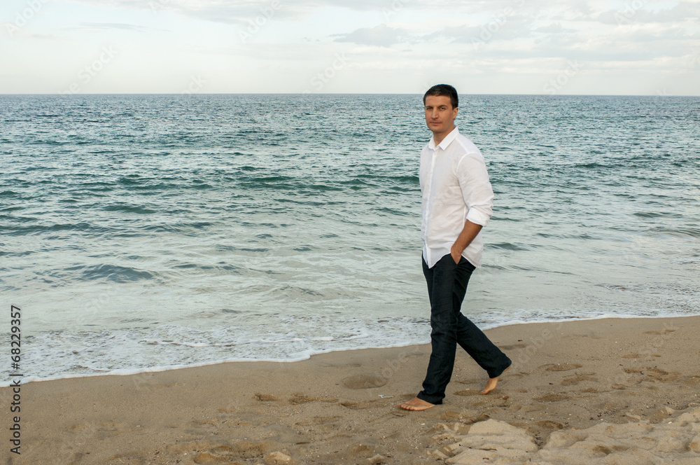 Ragazzo in camicia cammina in riva al mare Ragazzo in camicia cammina in riva al mare