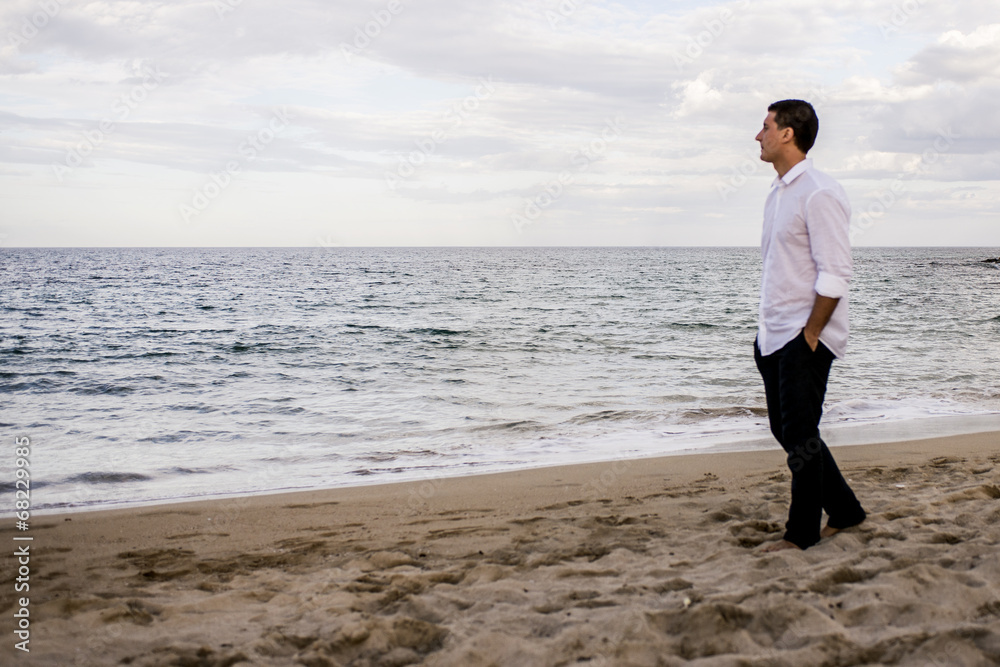 Ragazzo in camicia cammina in riva al mare