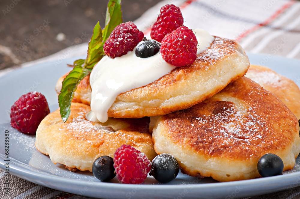 Cheesecakes with sour cream decorated with berries Cheesecakes with sour cream decorated with berries