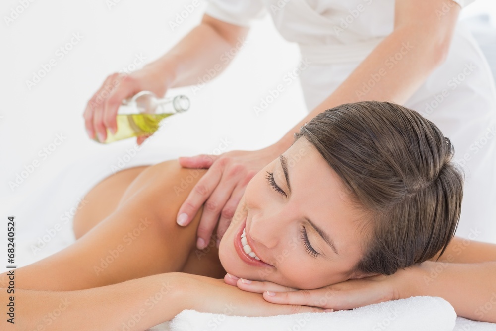Attractive woman getting massage oil on her back