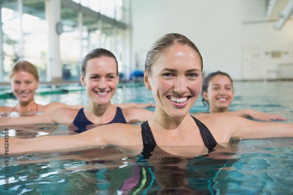 Smiling female fitness class doing aqua aerobics Smiling female fitness class doing aqua aerobics