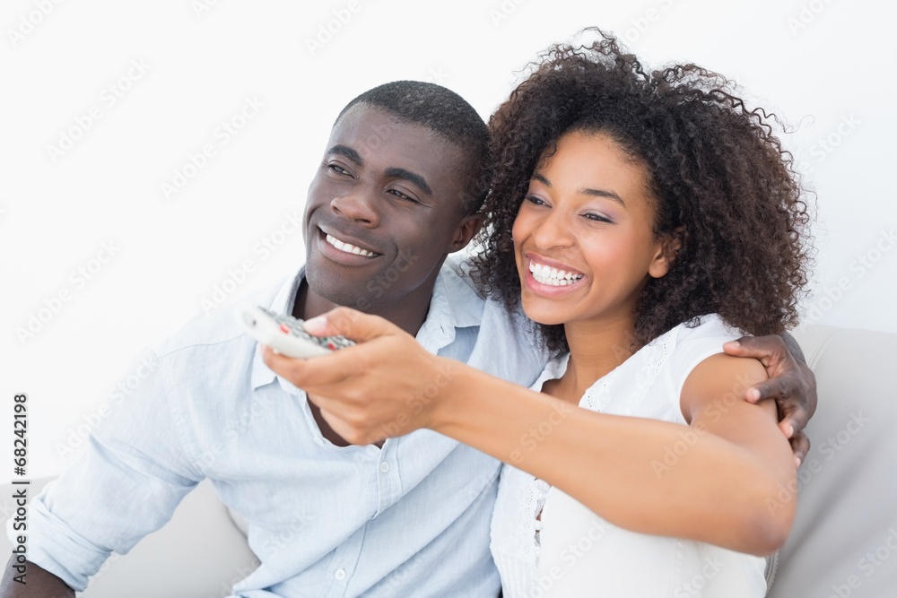 Couple sitting on couch together watching tv Couple sitting on couch together watching tv