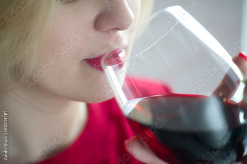 Woman drinking red wine with red lips - close portrait