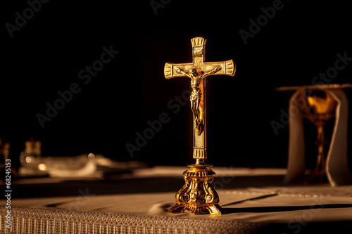 Catholic cross on altar in church lit by sunlight Fototapeta