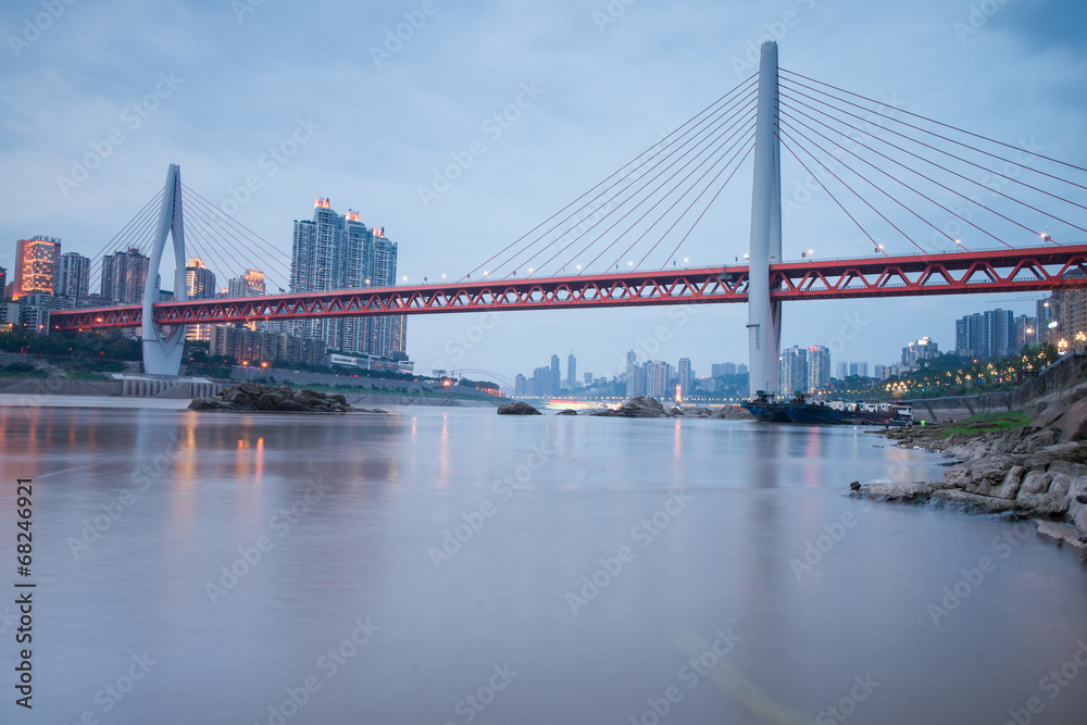 Naklejka premium Modern bridge at sunset time with city background