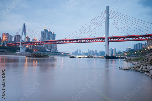 Modern bridge at sunset time with city background