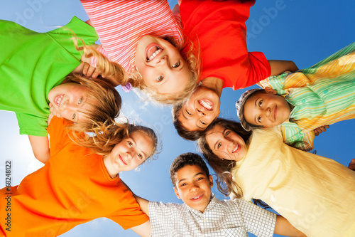 Happy kids close in circle on sky background