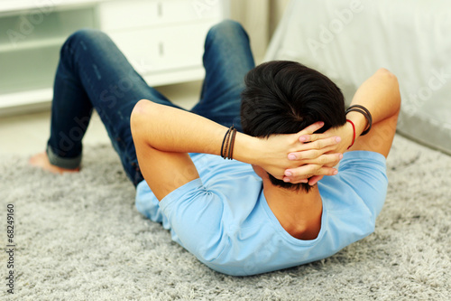 Young asian man exercising abdominals on the floor at home