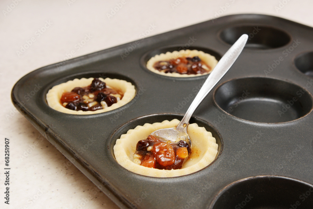 Spooning mincemeat into pastry cases Spooning mincemeat into pastry cases