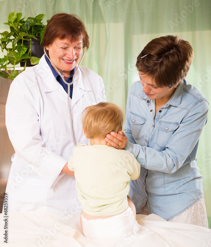 Happy   pediatrician doctor examining toddler