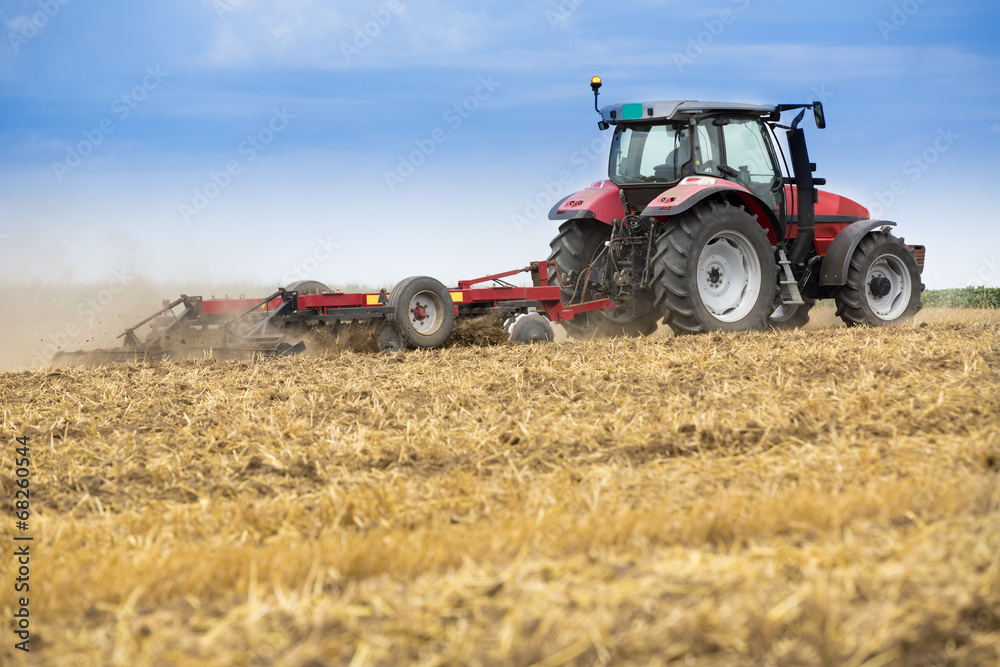 Tractor cultivating wheat stubble field, crop residue. Tractor cultivating wheat stubble field, crop residue.