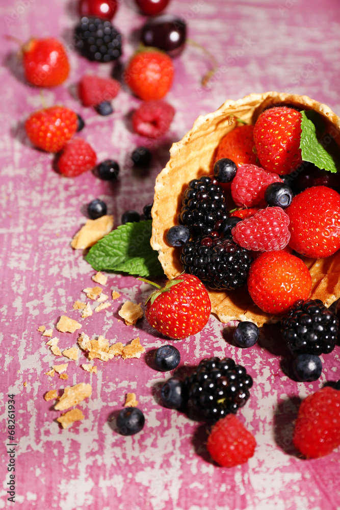 Different ripe berries in sugar cone, on purple background Different ripe berries in sugar cone, on purple background