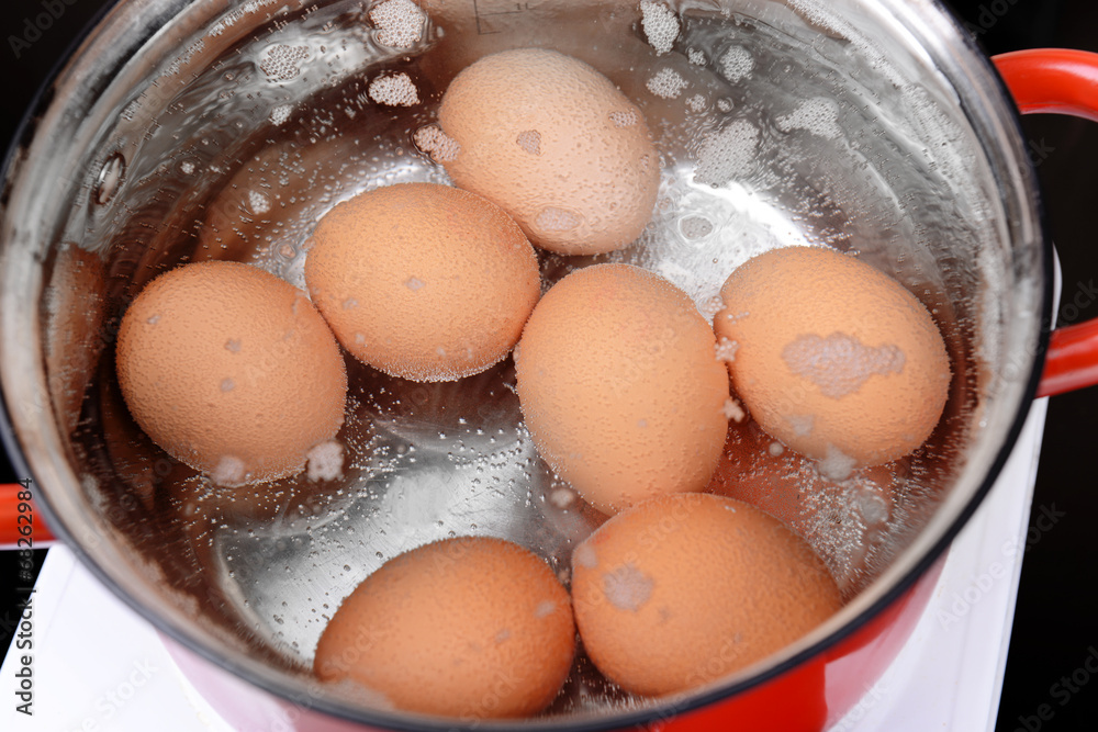 Eggs in boiling water in pan on electric hob Eggs in boiling water in pan on electric hob