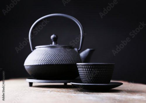 Chinese traditional teapot on wooden table, on dark background