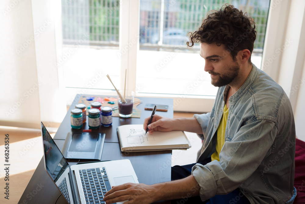 handsome hipster modern man working home using laptop