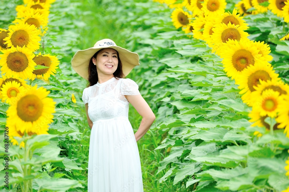 ひまわり畑に立っている白いワンピースと麦わら帽子を着ているアジア人の美しい女性 Stock Photo Adobe Stock
