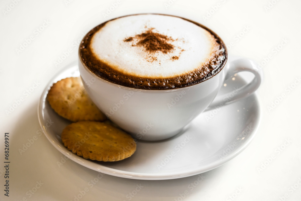 Coffee cup and cracker on white table with reflect in cafe Coffee cup and cracker on white table with reflect in cafe