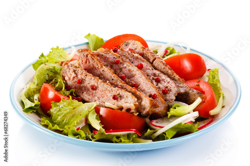 Grilled meat and vegetables on white background