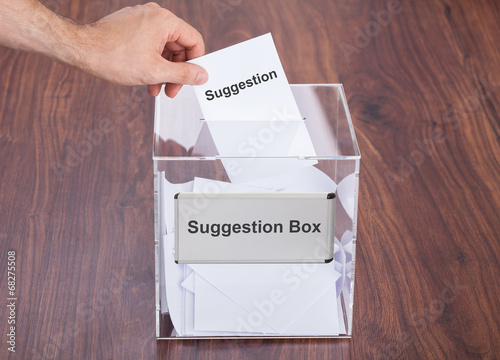 Businessman Placing Suggestion Slip Into Box