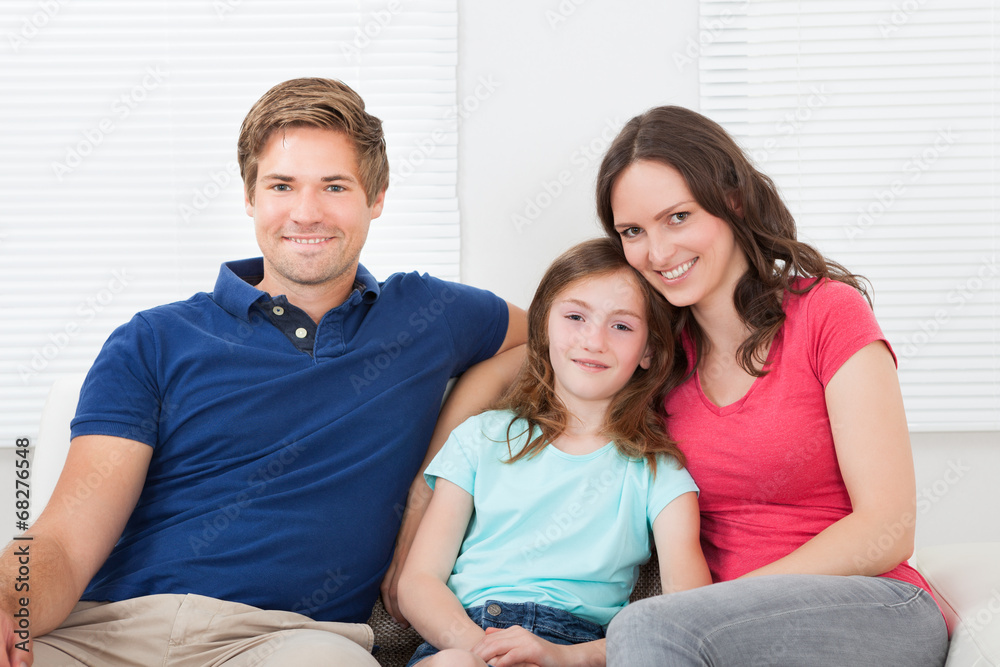 Family Sitting On Sofa At Home