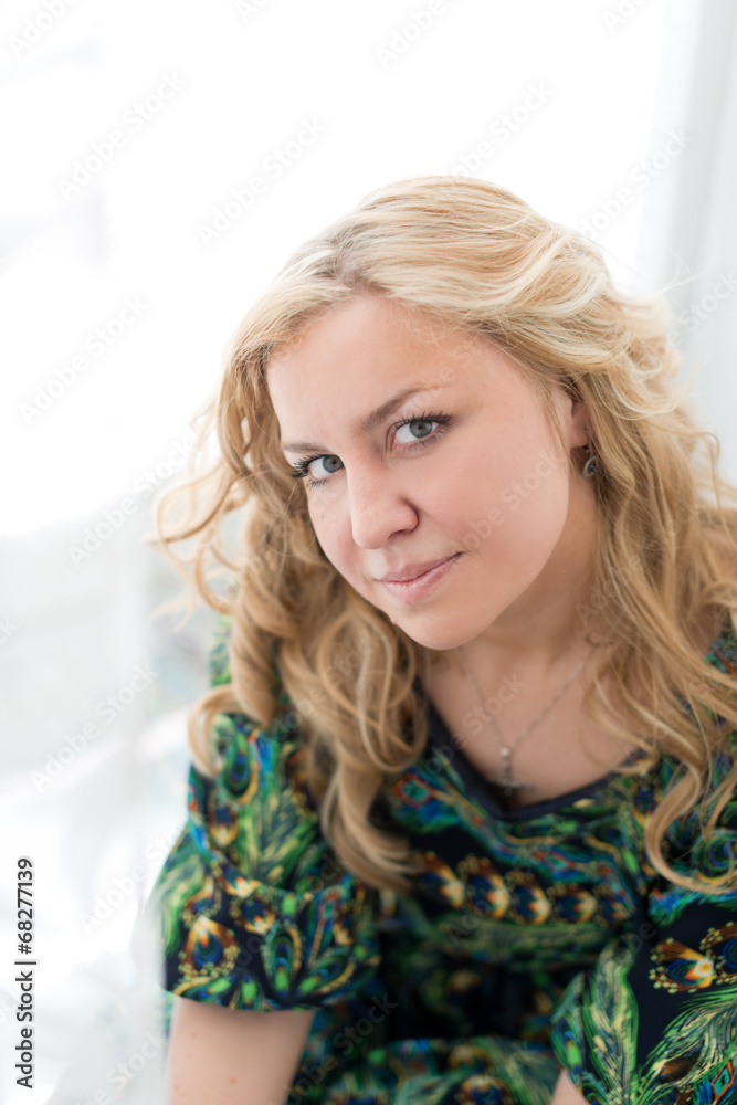 Fototapeta premium Young attractive woman against the white curtains