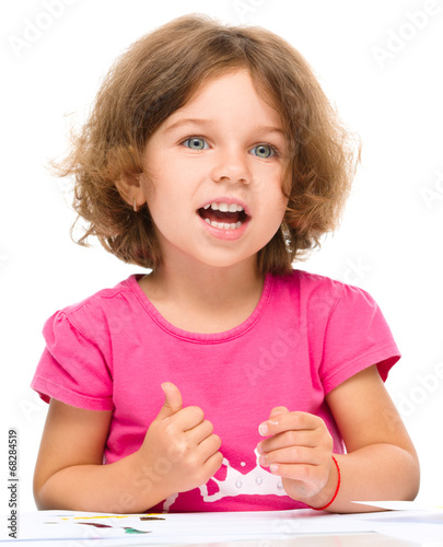 Little girl is painting with gouache