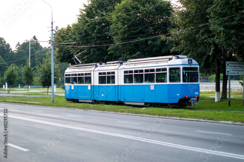Municipal blue tram rides through the roads of the city